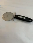 Farberware Professional Stainless Steel Pizza Cutter With Black Handle. Fixed Price $5.00.